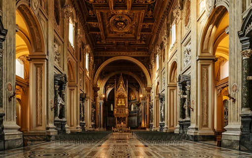 St. John Lateran Basilica interior with ornate ceiling and altar, Rome, Italy.