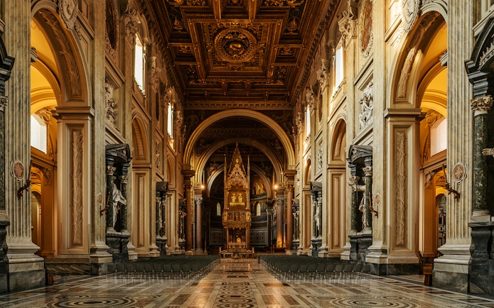 St. John Lateran Basilica interior with ornate ceiling and altar, Rome, Italy.