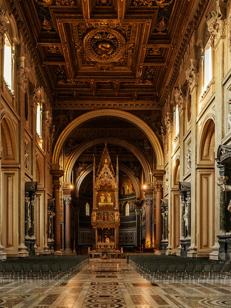 St. John Lateran Basilica interior with ornate ceiling and altar, Rome, Italy.