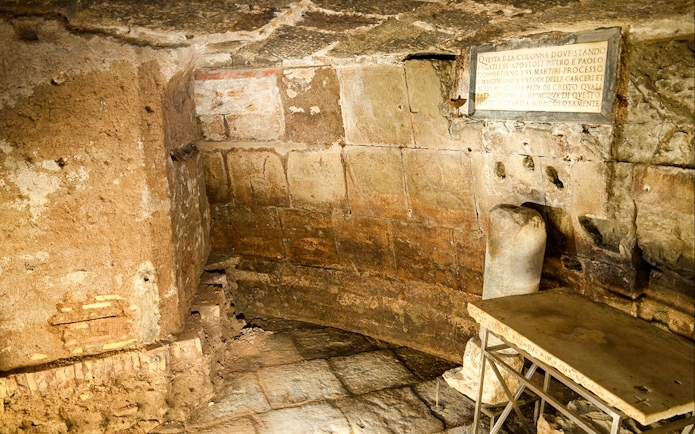 Mamertine Prison interior with ancient stone walls and inscription in Rome.