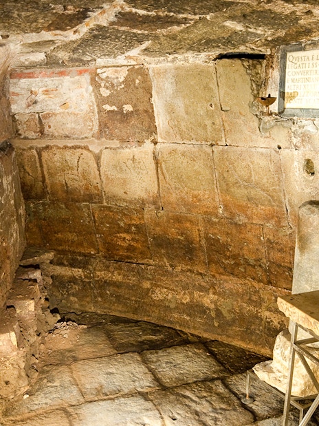 Mamertine Prison interior with ancient stone walls and inscription in Rome.