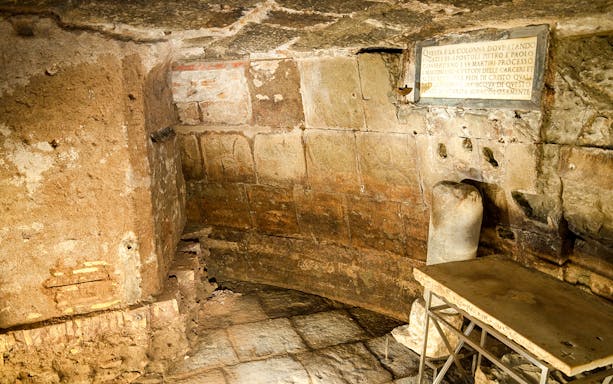 Mamertine Prison interior with ancient stone walls and inscription in Rome.