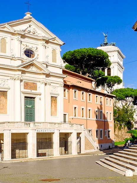 Mamertine Prison entrance with nearby historical buildings in Rome, Italy.