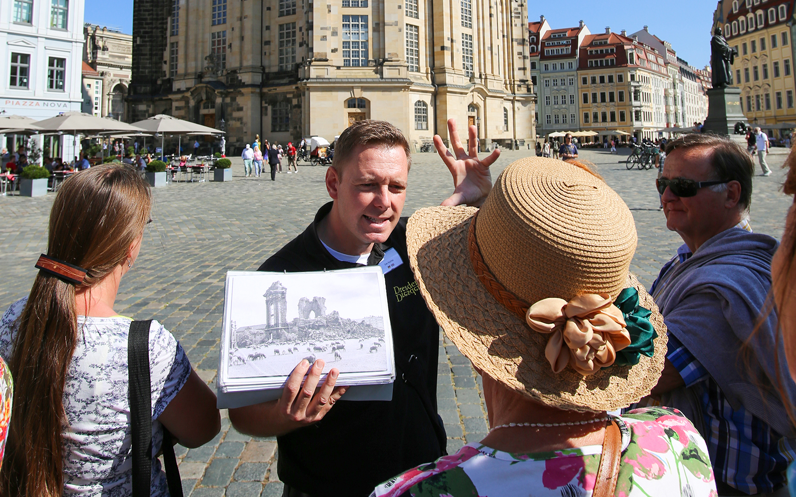 Tour guide explaining Dresden's history to a group in front of Frauenkirche.