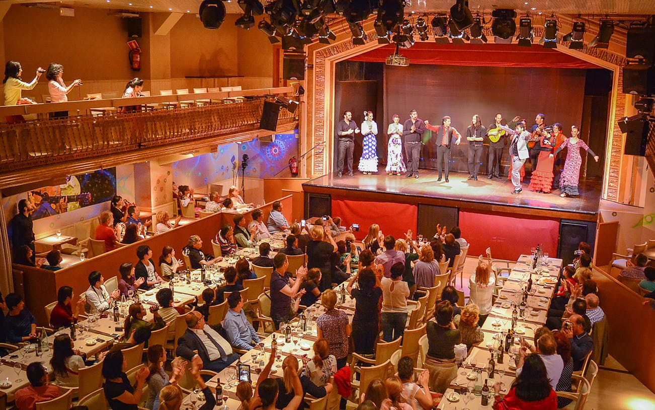 Flamenco performers on stage with audience dining in Madrid.