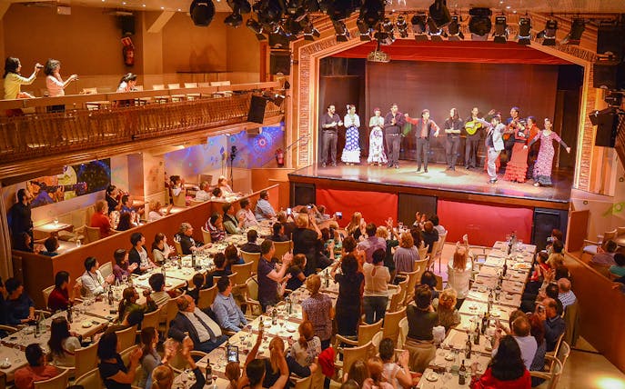 Flamenco performers on stage with audience dining in Madrid.