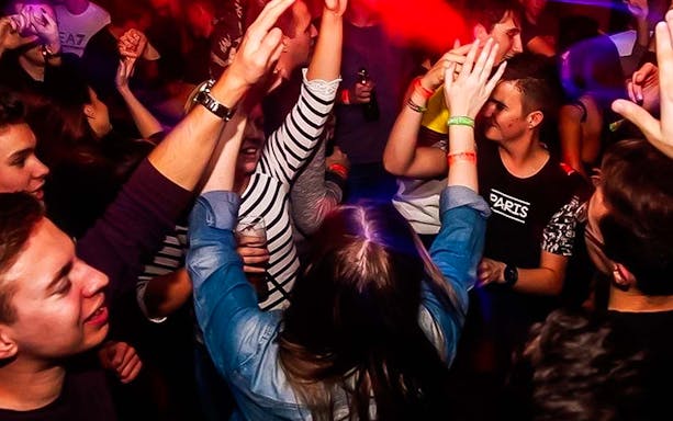 Crowd enjoying a lively pub crawl in Krakow.