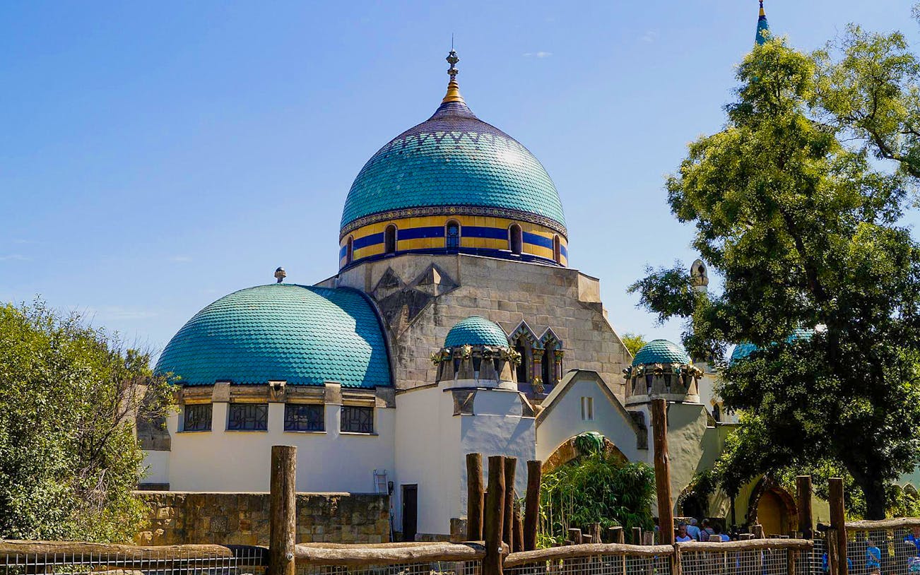 Budapest Zoo entrance with ornate domes and lush greenery.