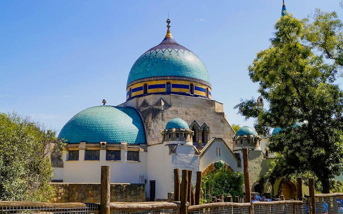 Budapest Zoo entrance with ornate domes and lush greenery.