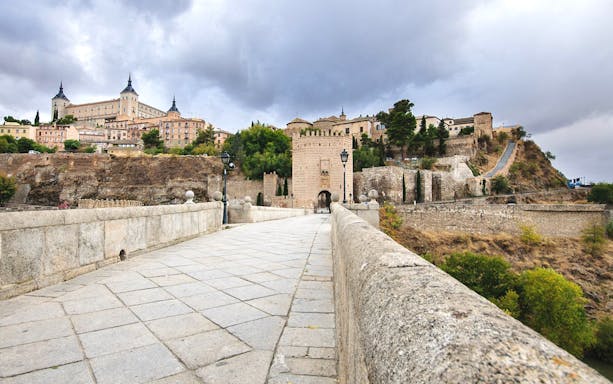 Toledo's Alcázar and Puerta de Bisagra on a cloudy day, part of the Madrid to Toledo tour.