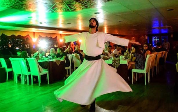 Dancer performing on Bosphorus dinner cruise with guests dining.