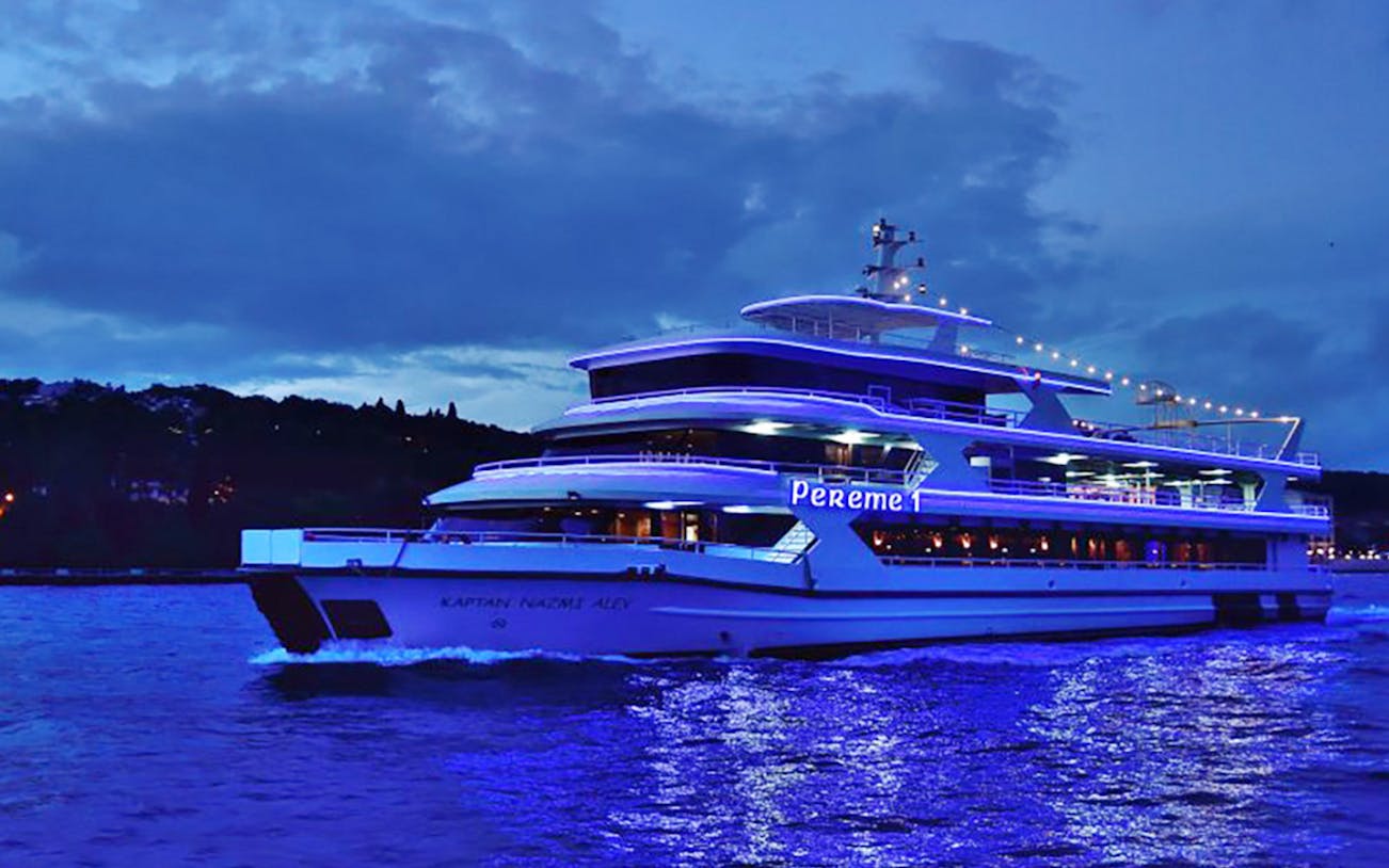 Bosphorus dinner cruise ship illuminated at night in Istanbul.