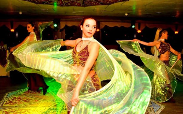 Dancers performing on a Bosphorus dinner cruise with flowing costumes.