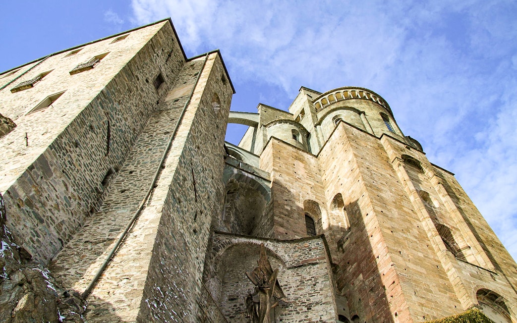 Sacra di San Michele stone facade under blue sky, part of Torino half-day medieval tour.