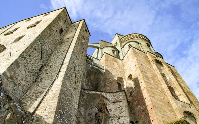 Sacra di San Michele stone facade under blue sky, part of Torino half-day medieval tour.
