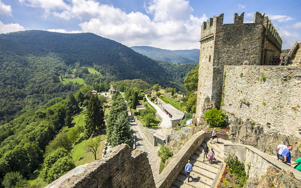 Visitors exploring the medieval Sacra di San Michele with scenic views of the Susa Valley, near Torino.