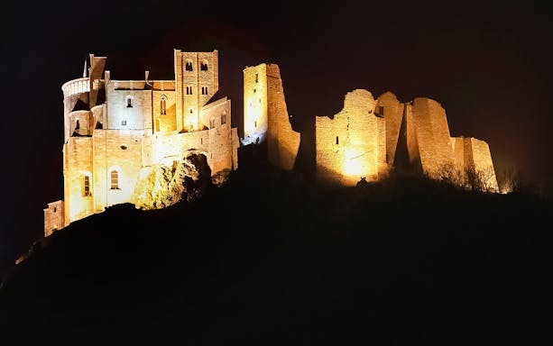 Sacra di San Michele illuminated at night, seen during a half-day tour from Torino.
