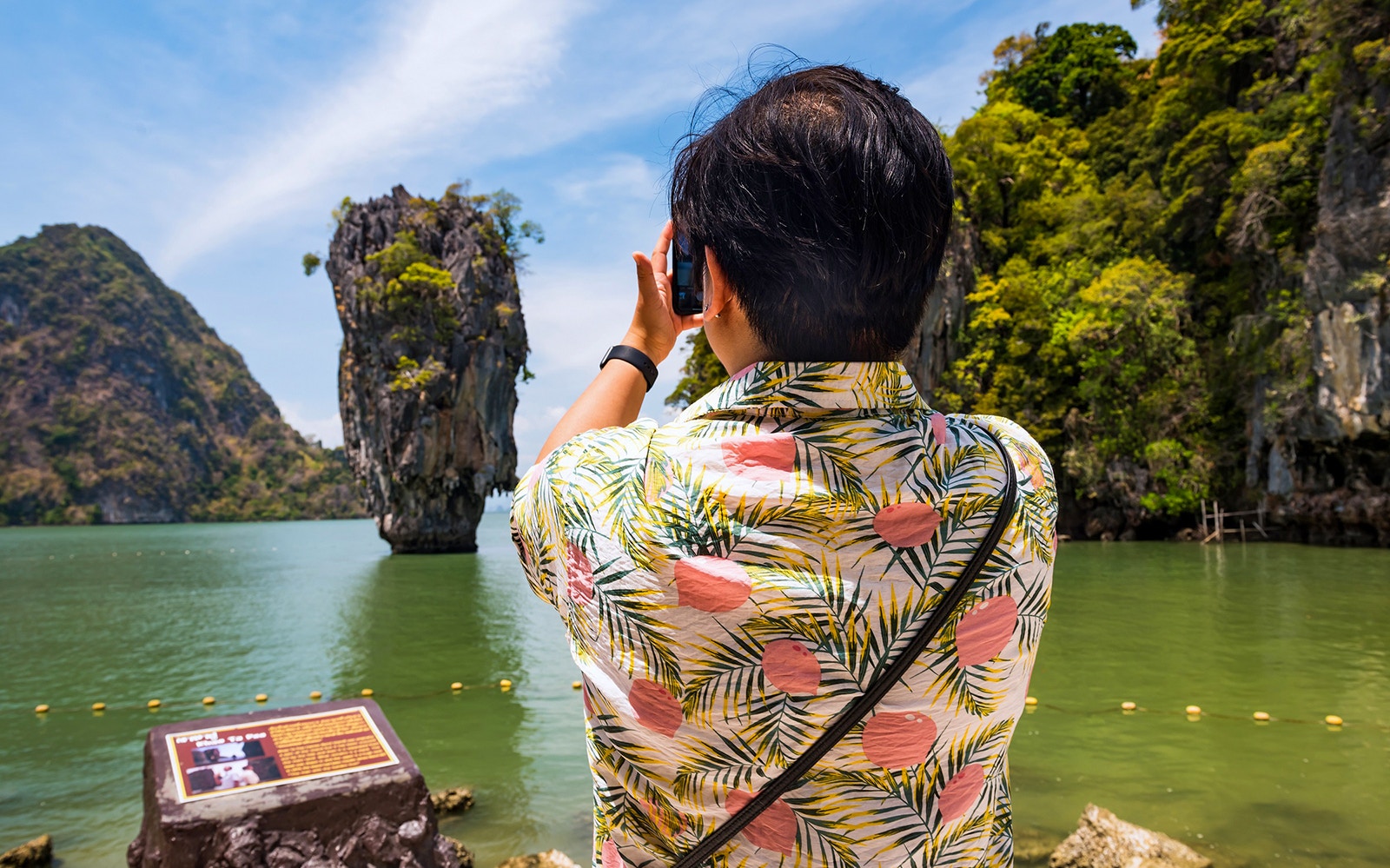Tourist photographing James Bond Island in Phang Nga Bay, Thailand.