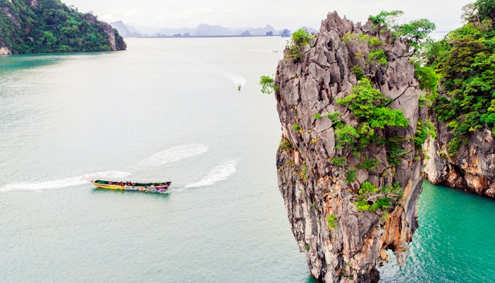 Canoe near limestone cliffs at James Bond Island, Thailand.
