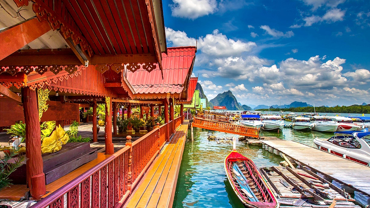 Traditional Thai architecture by the water with boats, James Bond Island tour.