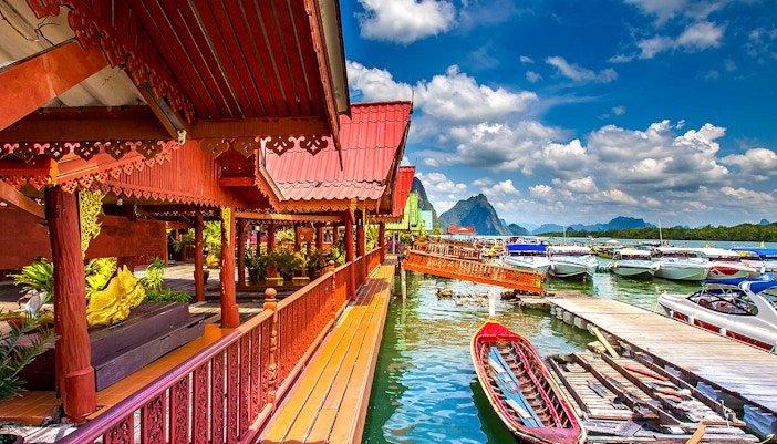 Traditional Thai architecture by the water with boats, James Bond Island tour.