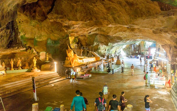 Cave temple with golden Buddha statues on James Bond Island tour.