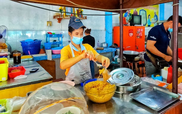 Street vendor preparing noodles on Phuket Michelin Food Tour.