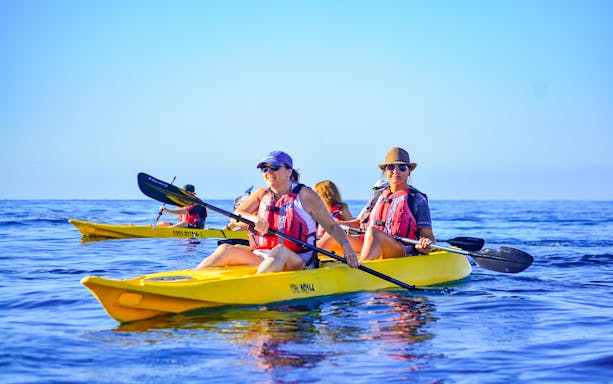 Kayakers in glass bottom kayaks on clear waters, Cabo San Lucas.
