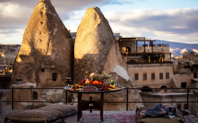 Lunch table with fruit and drink overlooking Cappadocia rock formations.