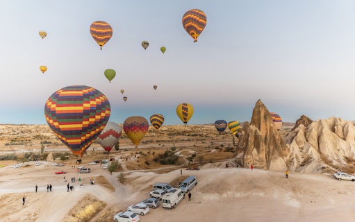 Hot air balloons over Cappadocia landscape during tour with lunch.