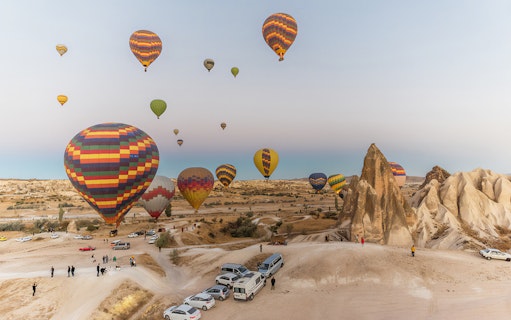 Hot air balloons over Cappadocia landscape during tour with lunch.