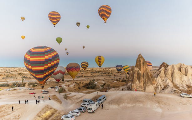 Hot air balloons over Cappadocia landscape during tour with lunch.