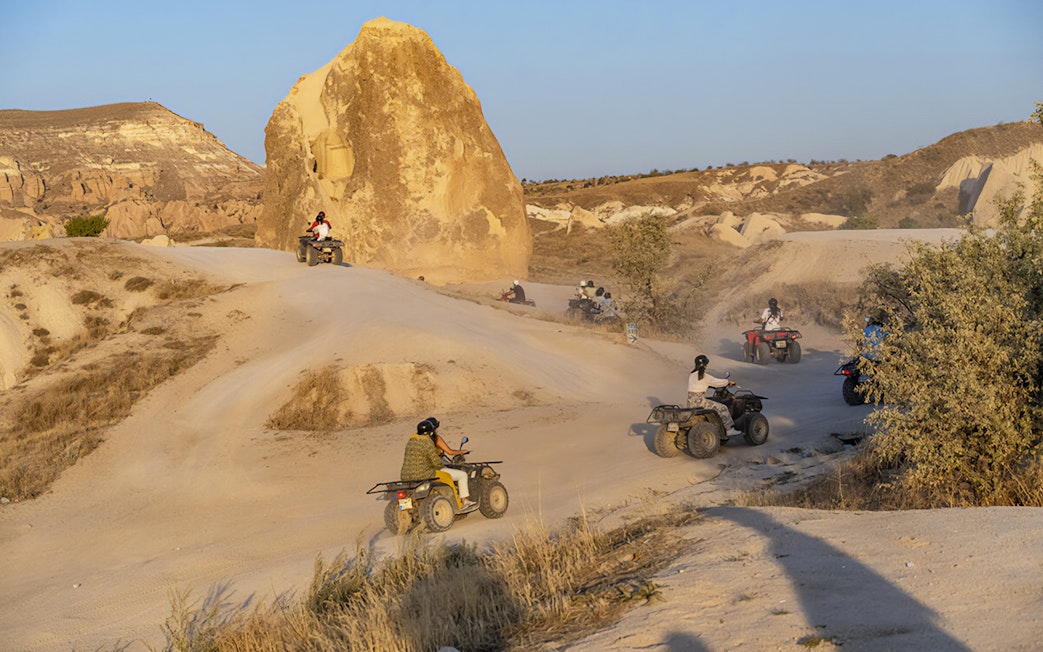 ATVs driving through Cappadocia's rocky landscape during a guided tour.