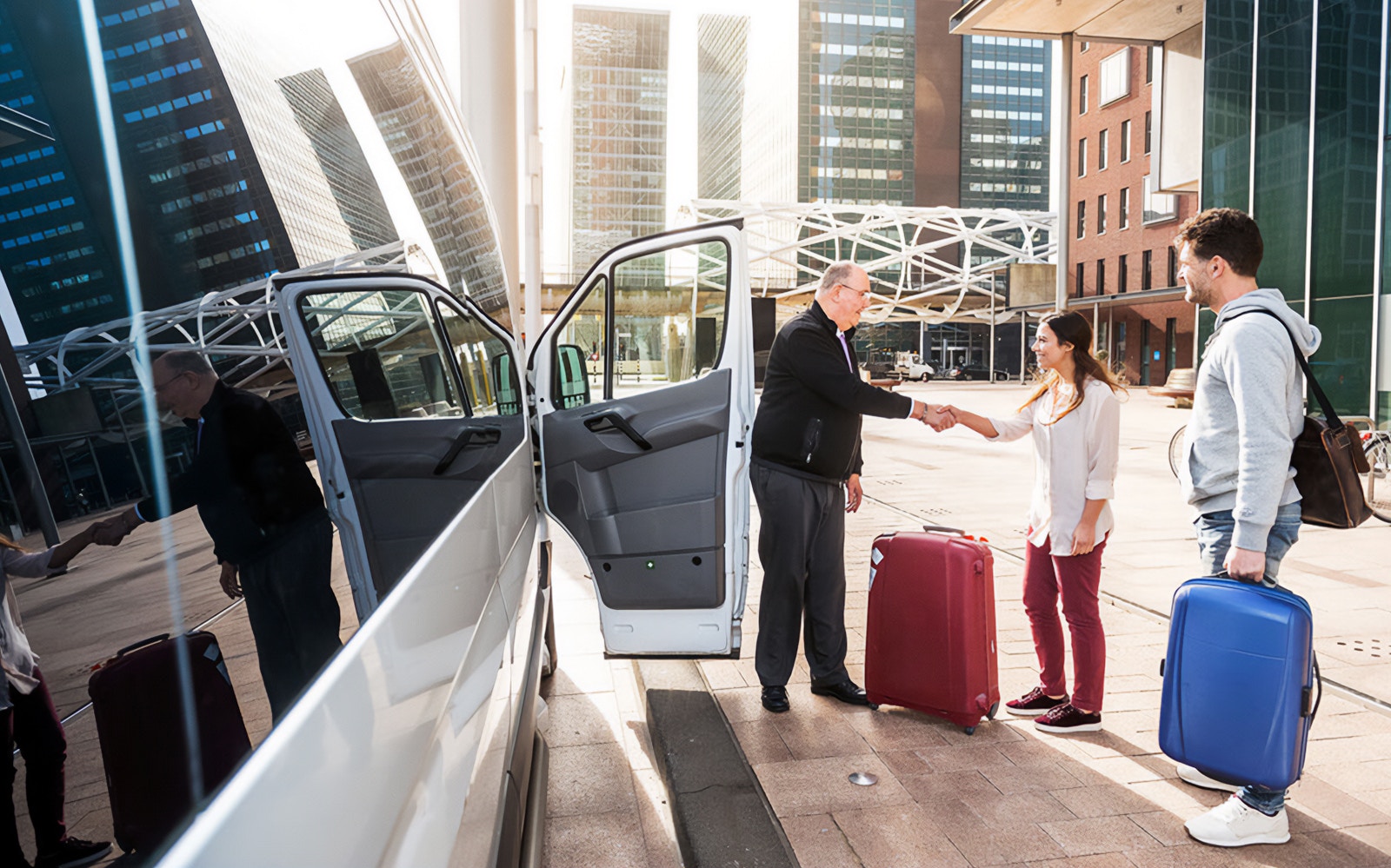 Shuttle driver greeting passengers with luggage outside Cappadocia airport.