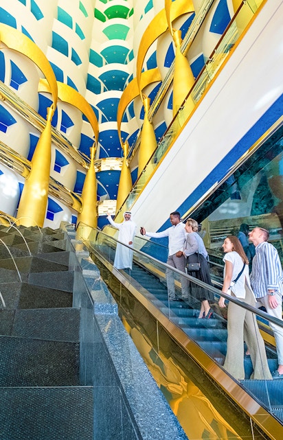 Visitors on an escalator during a guided tour inside Burj Al Arab, Dubai.