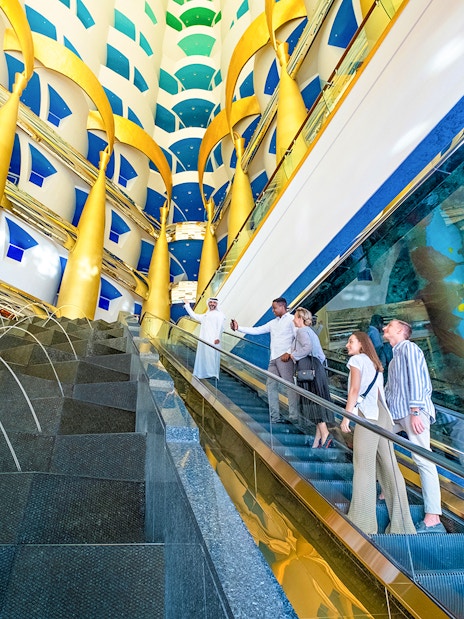 Visitors on an escalator during a guided tour inside Burj Al Arab, Dubai.