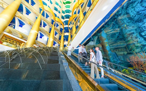 Visitors on an escalator during a guided tour inside Burj Al Arab, Dubai.