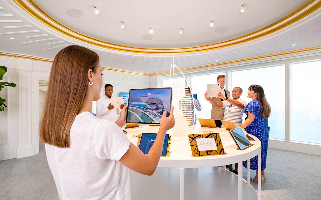 Visitors using tablets during a guided tour inside Burj Al Arab, Dubai.