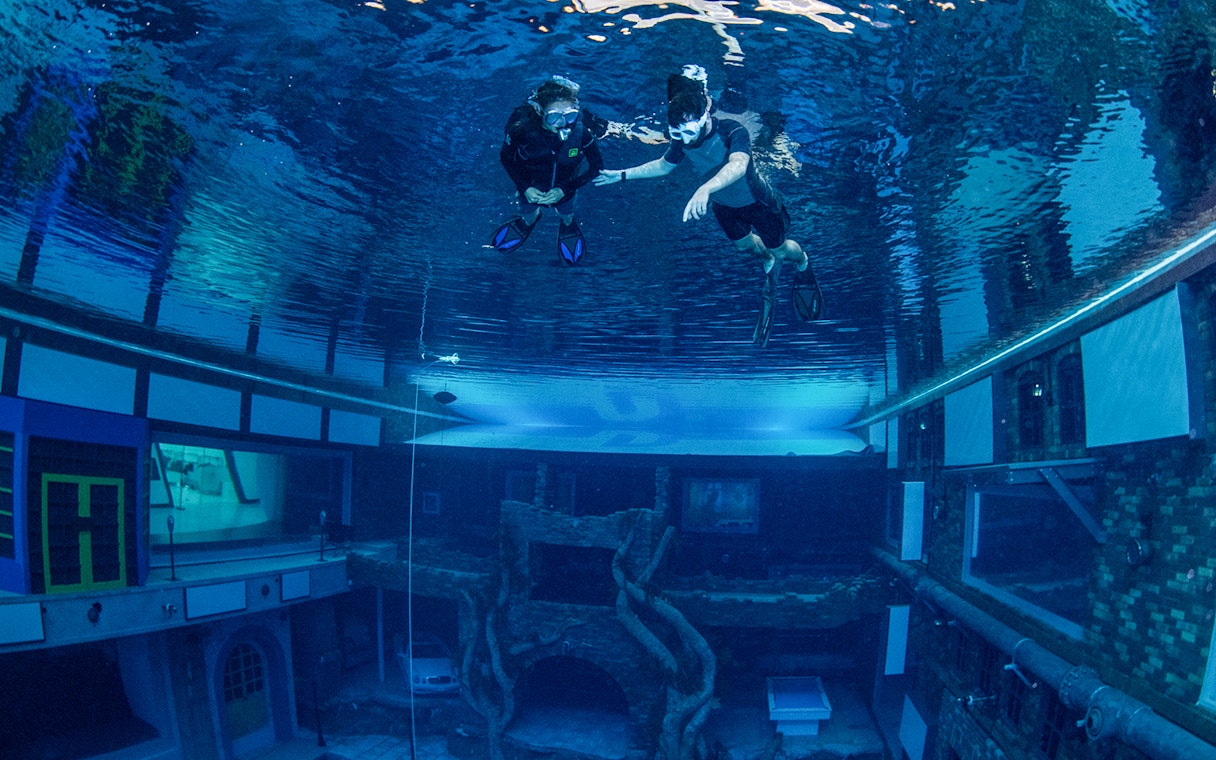 Snorkelers exploring underwater cityscape at Deep Dive Dubai.