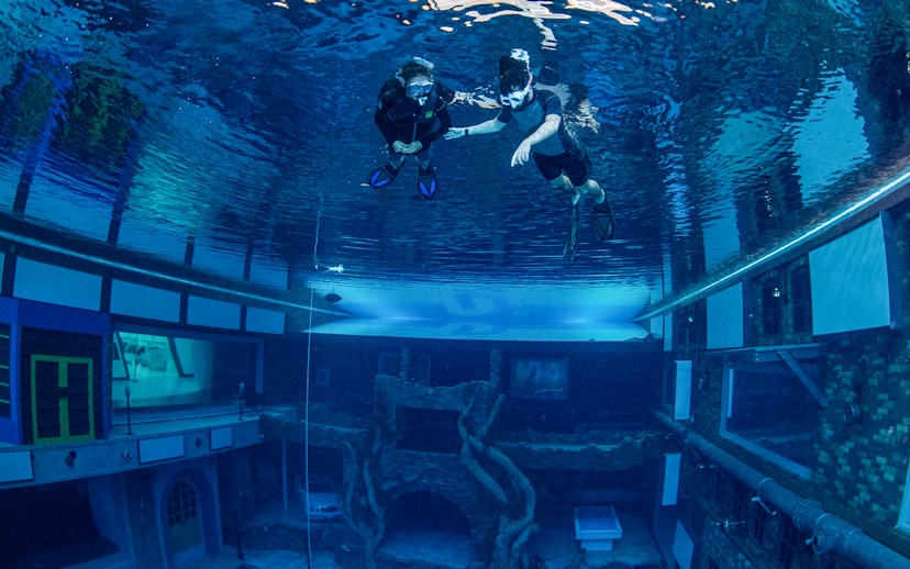 Snorkelers exploring underwater cityscape at Deep Dive Dubai.