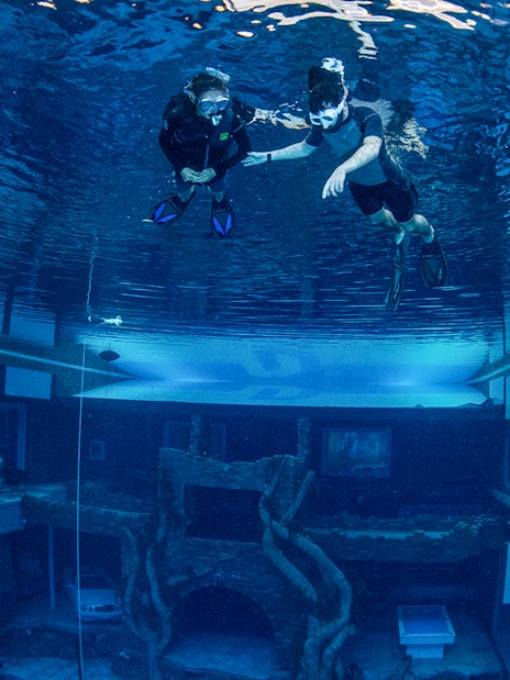 Snorkelers exploring underwater cityscape at Deep Dive Dubai.