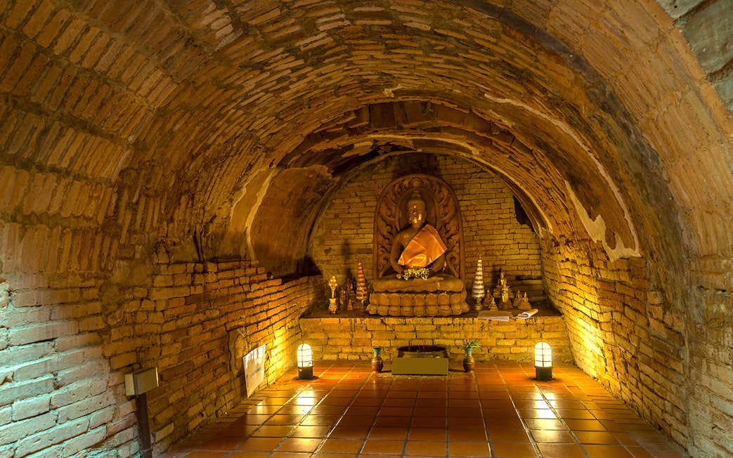 Buddha statue in a brick alcove at Wat Pha Lat, part of the Doi Suthep sunrise tour.