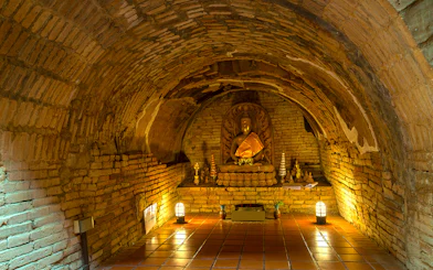 Buddha statue in a brick alcove at Wat Pha Lat, part of the Doi Suthep sunrise tour.