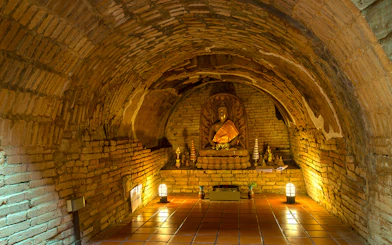 Buddha statue in a brick alcove at Wat Pha Lat, part of the Doi Suthep sunrise tour.