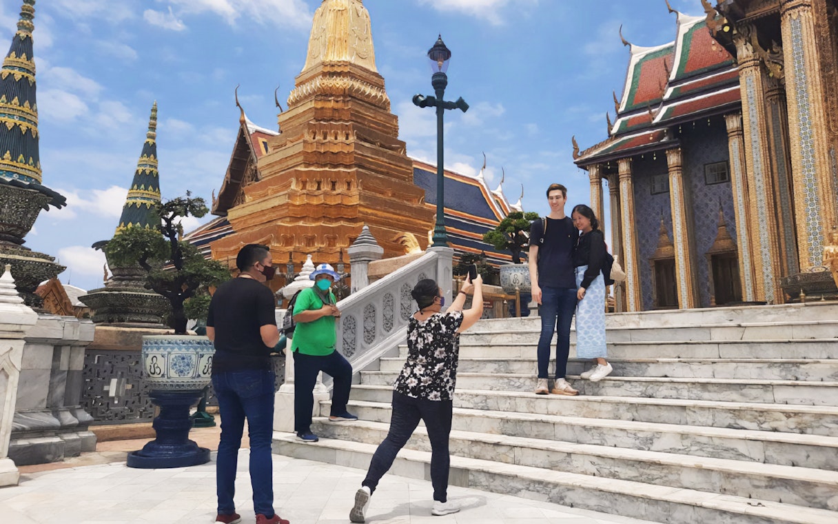 Visitors at Grand Palace, Bangkok, posing for photos near Wat Phra Kaew during a walking tour.