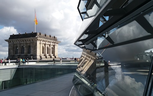 Reichstag building and glass dome with visitors in Berlin, Germany.