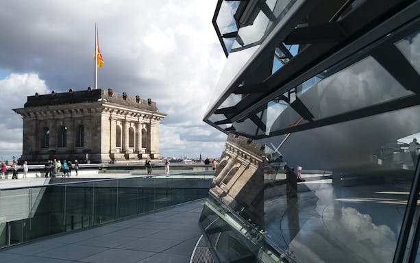 Reichstag building and glass dome with visitors in Berlin, Germany.
