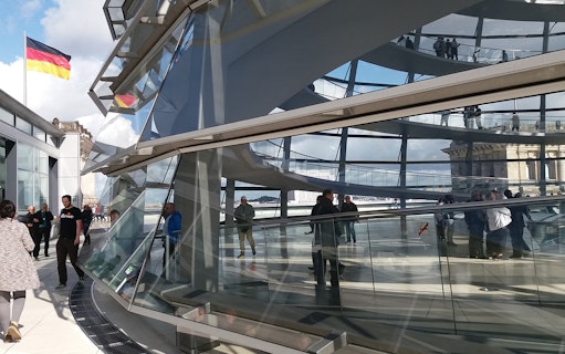 Reichstag Glass Dome interior with visitors on a multi-lingual guided tour in Berlin.