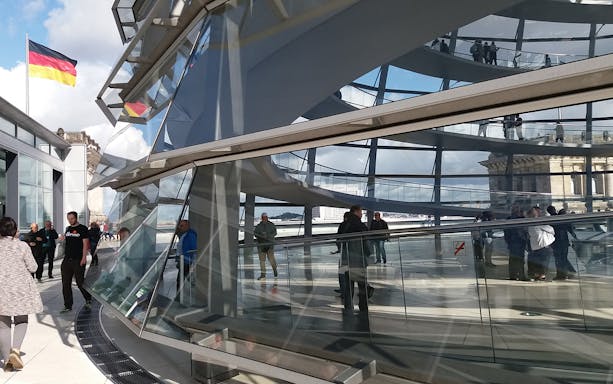 Reichstag Glass Dome interior with visitors on a multi-lingual guided tour in Berlin.