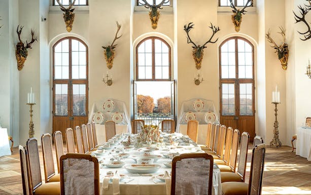 Dining room in Moritzburg Castle with ornate table setting and antler decor.